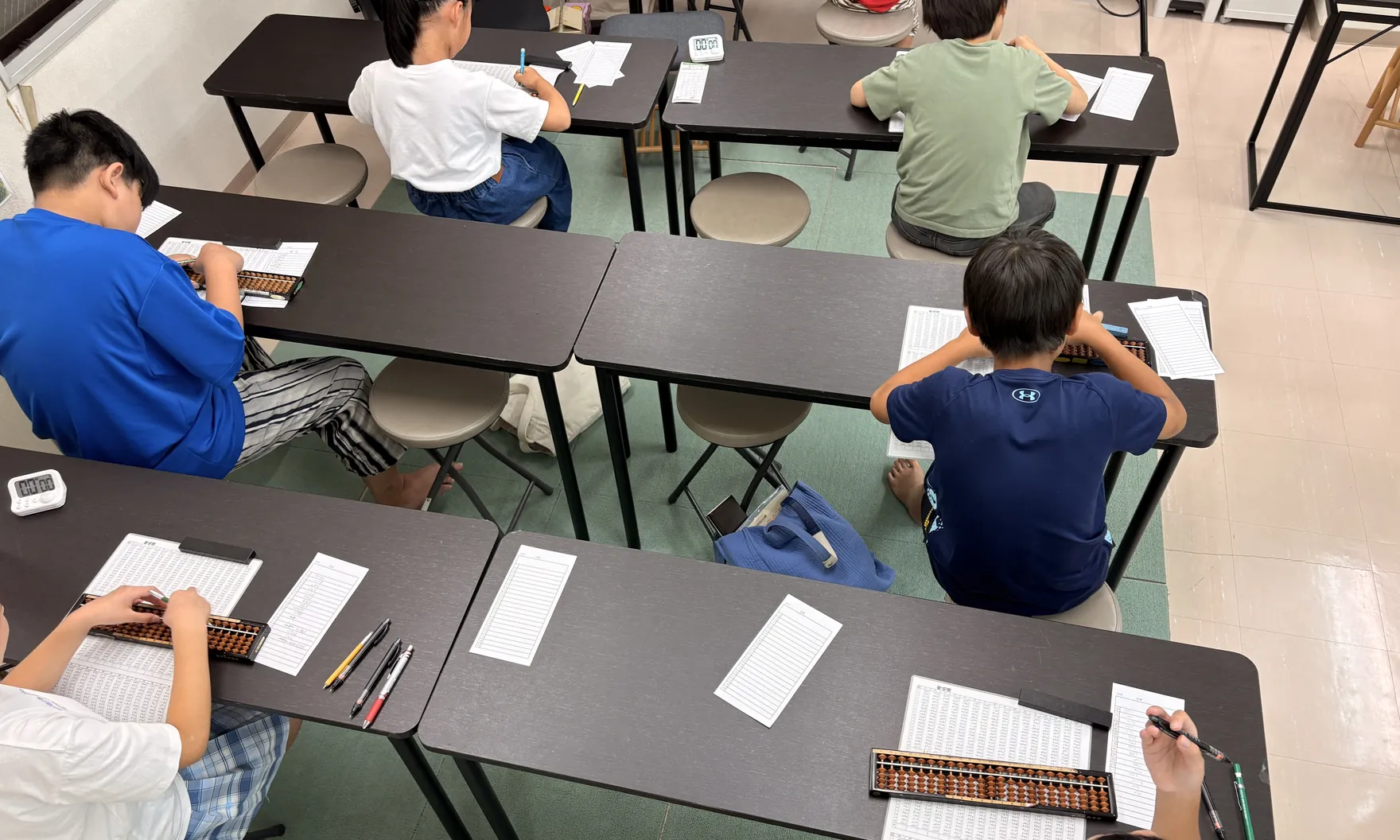 주산학원의 모습. 학생이 각자의 책상에서 문제지와 주판을 마주하고 있다